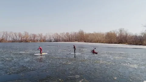 Aerial view of two athletes on the SUP and kayaker. Winter. Ice. Stock Footage 73297589