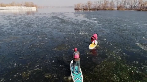 Aerial view of two athletes on the SUP. Winter. Ice. Stock Footage 73297723