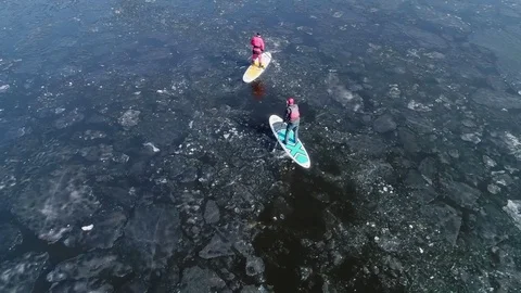 Aerial view of two athletes on the SUP. Winter. Ice. Stock Footage 73297768