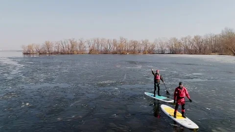 Aerial view of two athletes on the SUP. Winter. Ice. Stock Footage 73297799