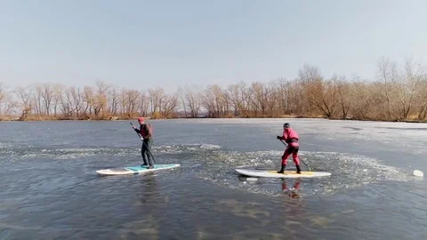 Aerial view of two athletes on the SUP. Winter. Ice. Stock Footage 73297861