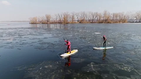 Aerial view of two athletes on the SUP. Winter. Ice. Stock Footage 73298102