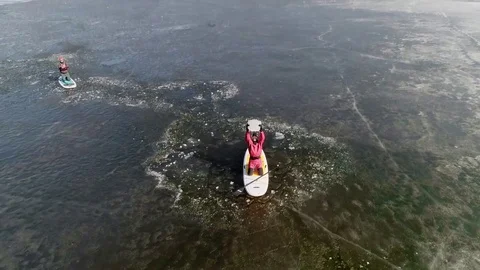 Aerial view of two athletes on the SUP. Winter. Ice. Slowmotion. Stock Footage 73299180