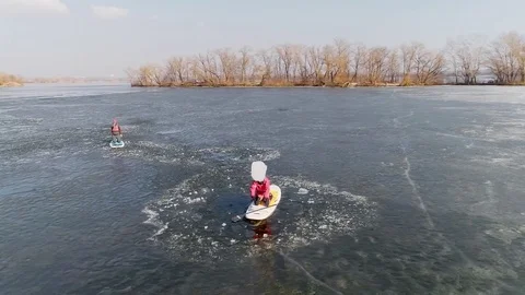 Aerial view of two athletes on the SUP. Winter. Ice. Slowmotion. Video stock 73299293
