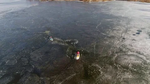Aerial view of two athletes on the SUP. Winter. Ice. Slowmotion. Stock Footage 73299619