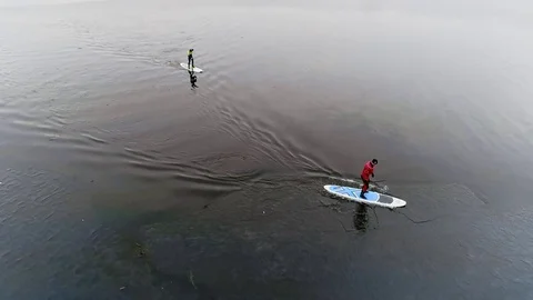 Aerial view of two athletes on the SUP. Winter. Ice. Stock Footage 73589793