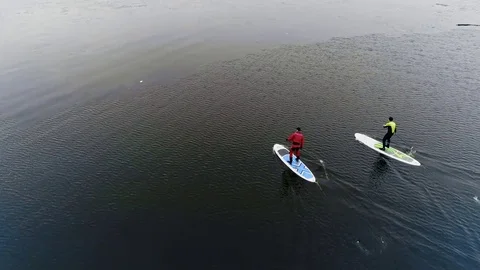 Aerial view of two athletes on the SUP. Winter. Ice. Stock Footage 73590219