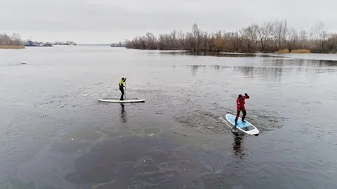 Aerial view of two athletes on the SUP. Winter. Ice. Stock Footage 73590417