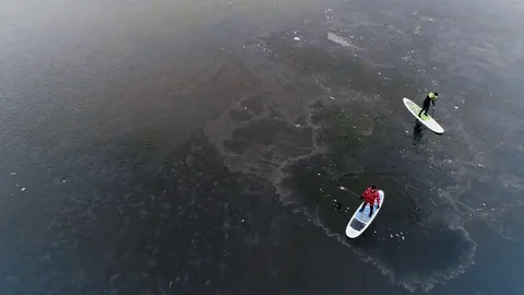 Aerial view of two athletes on the SUP. Winter. Ice. Stock Footage 73590529