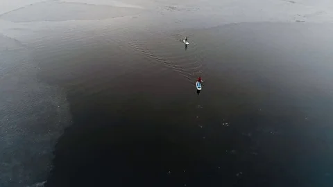 Aerial view of two athletes on the SUP. Winter. Ice. Stock Footage 73590690