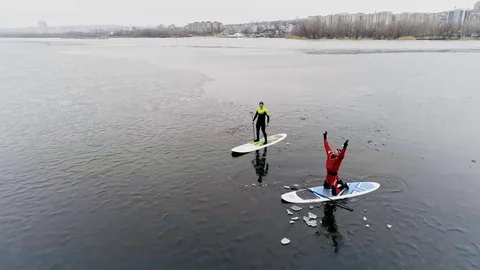 Aerial view of two athletes on the SUP. Winter. Ice. Stock Footage 73591285
