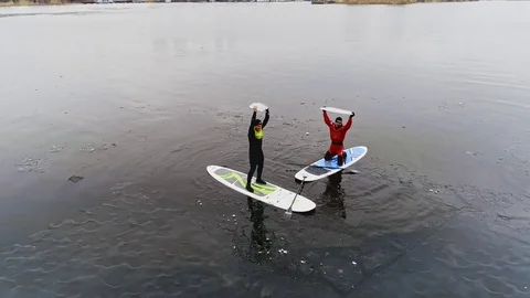 Aerial view of two athletes on the SUP. Winter. Ice. Stock Footage 73591453