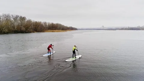 Aerial view of two athletes on the SUP. Winter. Ice. Stock Footage 73593067