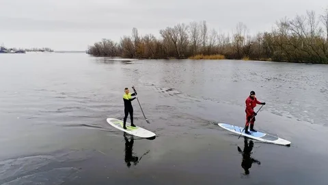 Aerial view of two athletes on the SUP. Winter. Ice. Stock Footage 73593535