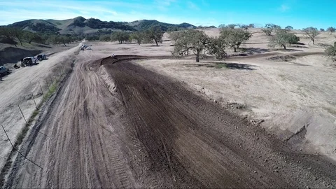 Aerial view of two bikers doing jumps on a desert race track Stock Footage 92106119