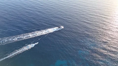 Aerial view of two boats gliding through the calm blue sea, leaving white wake Stockbeeldmateriaal 341126440
