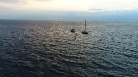 Aerial view. Two boats without sails go over small waves at sunset. Vídeo Stock 98154050