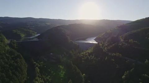 Aerial View of Two Dams Blocking Mountain Lakes with Blinding Sunlight Stock Footage 315618842