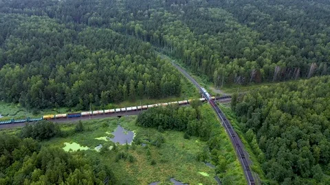 Aerial view of two freight trains cross at right angles in the middle of the Stock Footage 112950863