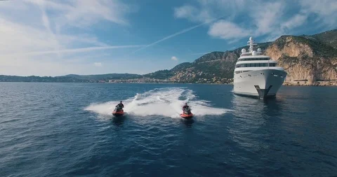 Aerial view of two Jet Ski ride near Super Yacht at Sunset. Stock Footage 116598361