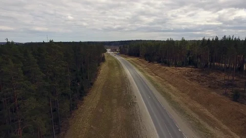 Aerial view of two-lane forest road with cars trucks moving.  Stock Footage 84499735