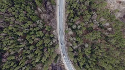 Aerial view of two-lane forest road with cars trucks moving Stock Footage 84500019