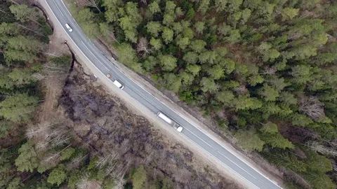 Aerial view of two-lane forest road with cars trucks moving 库存影片 84500890