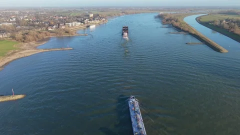 Aerial view of two large cargo ships navigating wide river with grassy banks Vídeo Stock 331281619
