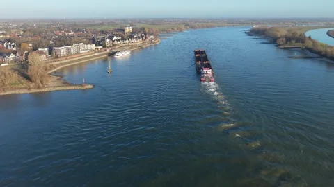Aerial view of two large cargo ships navigating a wide river with grassy banks Video stock 332739762