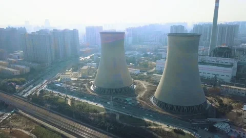Aerial View of Two Massive Cooling Towers at Power Plant with City Background 库存影片 334704747