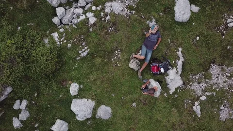 Aerial view Two men rest on a meadow on Dolomites Alps, freedom felling Stock Footage 114354545