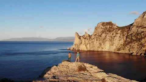 Aerial view two men stand on cliff top taking picture Video stock 103835770