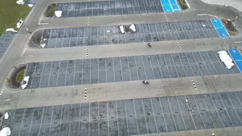 Aerial view of two motorcyclists practicing their driving skills in a parking Stock Footage 322769252