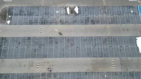 Aerial view of two motorcyclists practicing their driving skills in a shopping 库存影片 335887697