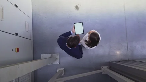 Aerial view of two people looking at tablet while discussing work Stock Footage 108445861