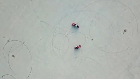 Aerial view of two red motorbikes racing high speed on a road in a circle way Stock Footage 111433372