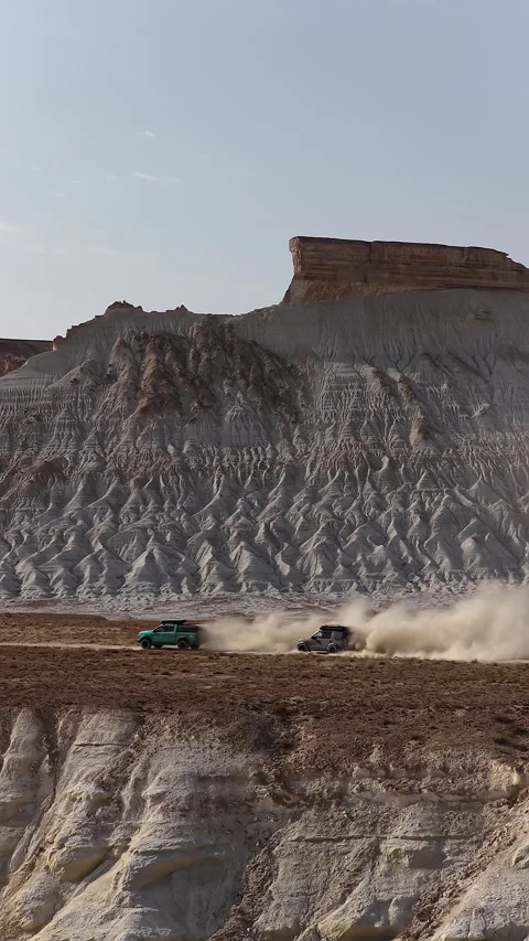 Aerial view of two off-road vehicles kicking up dust, Bozjyra, Mangystau Stock Footage 322804229