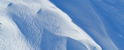 Aerial view of Two skiers going downhill off-piste in the Swiss Alps.  Stock Footage 121478261