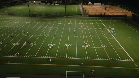 Aerial view of two teams playing football at night stadium Stock Footage 248144997