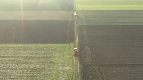 Aerial view of two tractors, one with mounted trailer and other has machine Stock Footage 171125058
