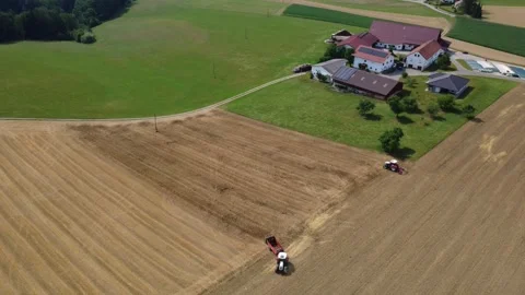 Aerial view of two tractors working on fields at a farm in summer Stock Footage 338326351