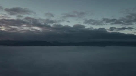Aerial view from UAV drone rising above mist early sunset Stock Footage 323619302