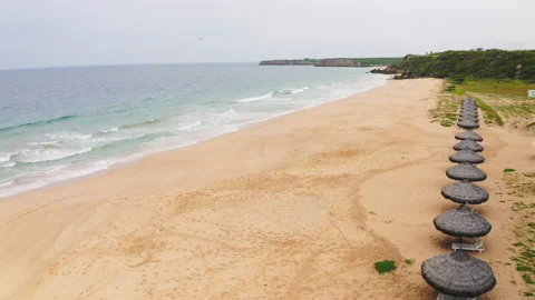 Aerial view of umbrellas on an empty pink sand beach (Playa Rosada) Video stock 154329194