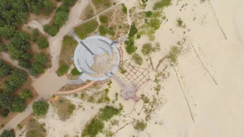 Aerial view of a unique circular observation deck in a sandy coastal or park are Stock Footage 321755376