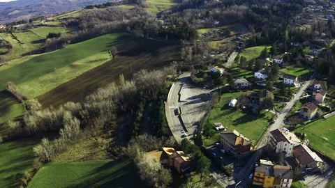 Aerial view of an unknown white car driving along rural road in Emilia-Romagna Stock Footage 104826411