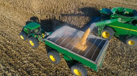 Aerial view of unloading corn grain into tractor trailer after harvest in field. Stock Photos