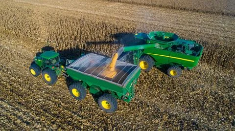 Aerial view of unloading corn grain into tractor trailer after harvest in field. Stock Photos