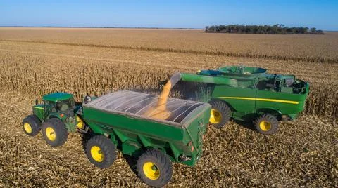 Aerial view of unloading corn grain into tractor trailer after harvest in field. Stock Photos