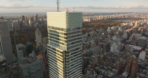 Aerial view of upper section of Bloomberg Tower above other town development Stock Footage 167730939
