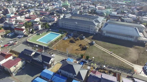 Aerial View of Urban Construction Site, School, and Swimming Pool Stock Footage 331231306